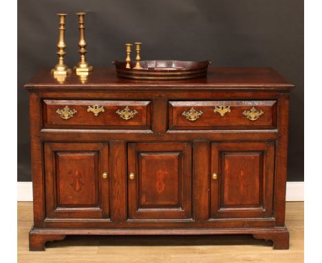 A George III oak low dresser, rectangular top above a pair of frieze drawers and three raised and fielded panel doors, brass 