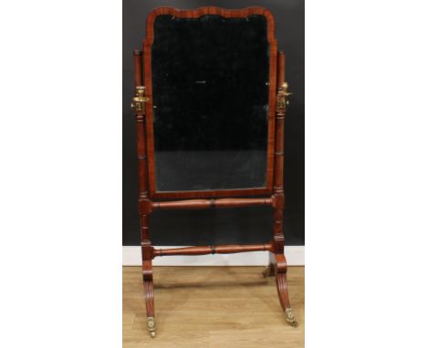 A Regency Revival mahogany cheval mirror, bevelled plate flanked by brass candlestick holders, turned stretcher, hipped reede