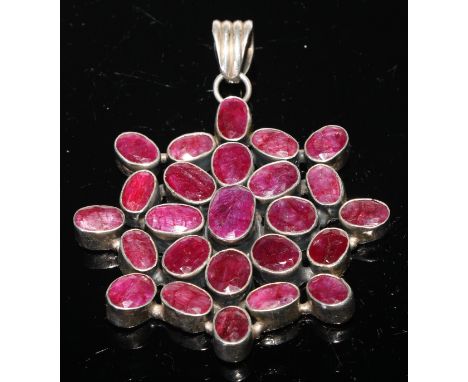 A large ruby pendant, the twenty five oval stones set in white metal, 8.5cm over loop 