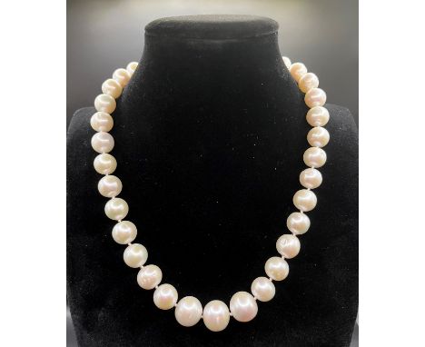 A single strand pearl necklace of 35 large slightly graduated pearls, from 11mm to 15mm in diameter, magnetic ball clasp