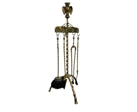 VICTORIAN BRASS FIRESIDE COMPANION STAND, with owl pediment over a twist column and tripod feet, with brush, shovel, tongs an