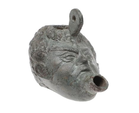 in the form of a child's head with the mouth as a projecting spout, a suspension loop from the forehead and a filing lamp in 