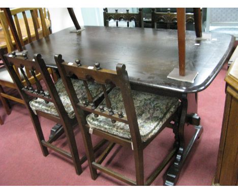 Refectory Table, with trestle ends, together with four Ercol chairs, on turned and block supports.