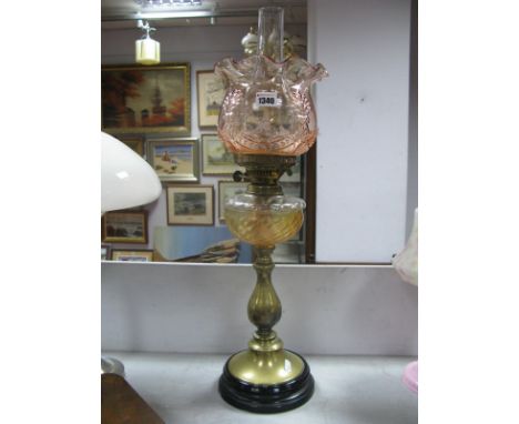 A Circa 1900 Oil Lamp, tinted shade and glass reservoir on brass baluster column, circular foot.