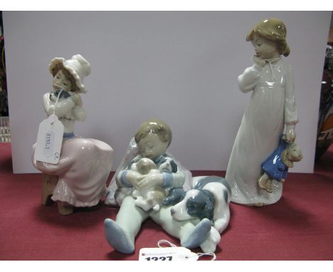 A Lladro Figurine, of a boy with puppies on his knee, together with two Nao figurines. (3) (boxed)