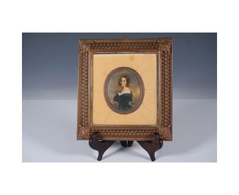 A finely detailed miniature portrait of a young lady set within an ornate filigreed metal frame. The oval portrait depicts a 