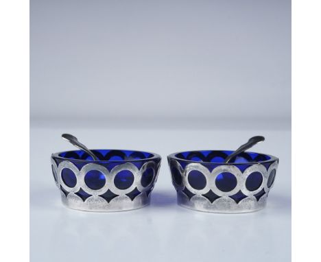 Elegant pair of salt cellars featuring deep cobalt blue glass inserts framed in intricately pierced sterling silver. The silv