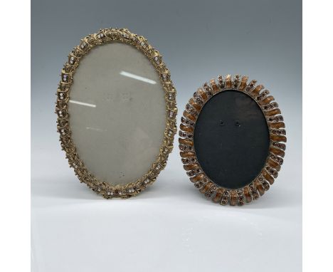 A set of two vintage ornate oval picture frames featuring intricate designs adorned with faux jewels. The larger frame measur