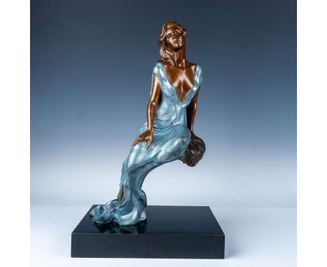 This elegant bronze sculpture depicts a serene woman seated gracefully on a rock, wearing a flowing blue dress. The piece sho