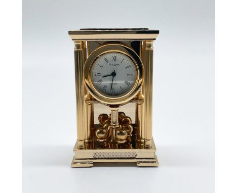 Charming miniature Bulova table clock with a gold-tone finish, crafted in 1988. This petite timepiece features Roman numeral 