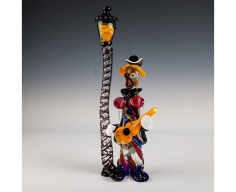 A vibrant handcrafted Murano glass clown sculpture accompanied by a whimsical street lamp. This colorful piece showcases intr