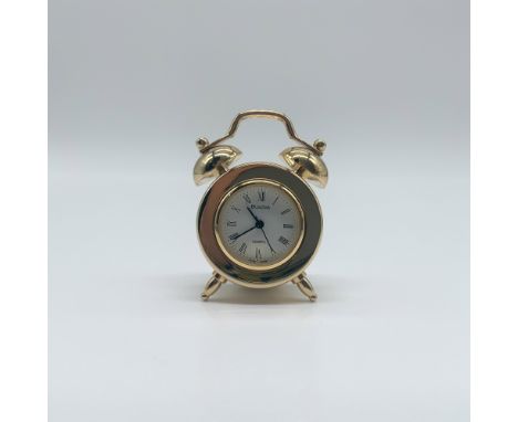 A 1.75”H Bulova miniature desk clock in a gold-tone metal case, styled after a classic twin bell alarm clock. Features a whit
