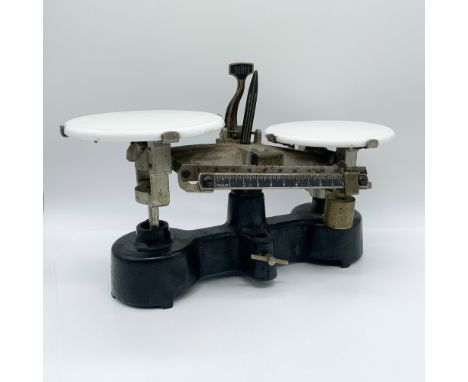 This antique balance scale by Central Scientific Co. stands 8.5” high and features a robust cast iron base with a sleek black