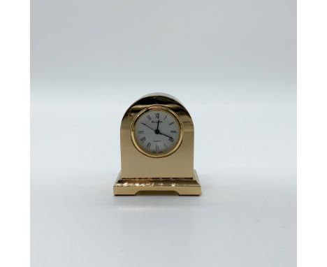 Vintage Bulova miniature desk clock with a gold-tone arched case, white dial, and black Roman numerals. Quartz movement, mark