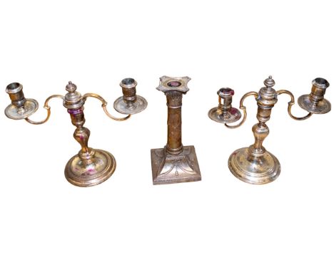 Two candelabra and a singular brass candlestick To be sold without reserve From the Gaia Servadio Collection