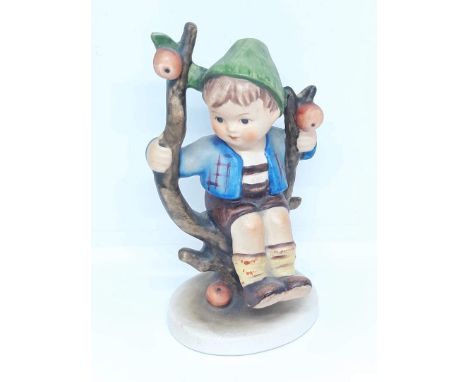 A Hummel figure depicting a boy sat in an apple tree. 