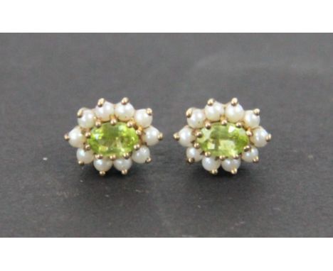 A pair of peridot and split seed pearl earrings, designed as a central oval peridot with a surround of ten seed pearls,all se