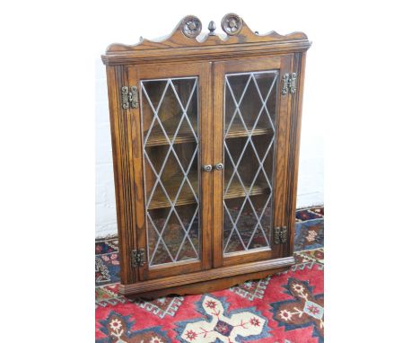 A carved light oak hanging corner cabinet, with lead glazed doors, 98cm; with a free a similar free standing oak corner cabin