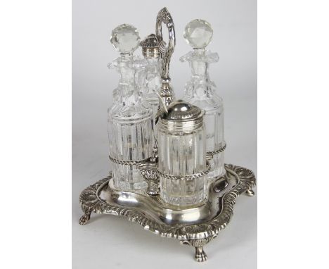 A late Victorian silver and cut glass cruet set, with two oil jars and stoppers, pepper and mustard, on stand cast with shell