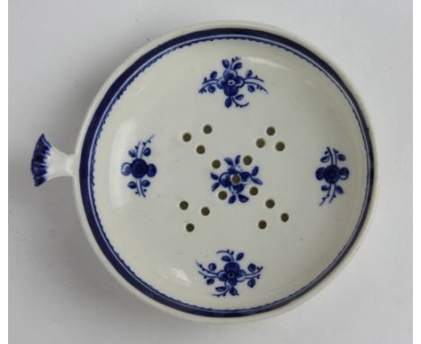 An 18th century Caughley blue and white porcelain egg strainer, with bud finial and decorated with sprigs, 9cm diameter 