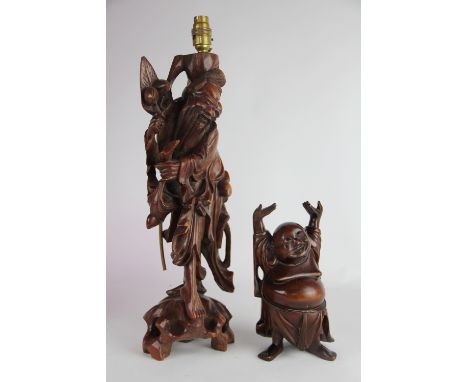 A Chinese carved hardwood figural lamp of a man gathering fruit, 47cm high (excluding fitting) and a carved hardwood figure o