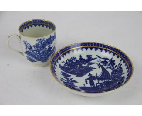 A Worcester coffee cup and saucer circa 1770, printed in underglaze blue with the Fisherman and Cormorant pattern, within gil