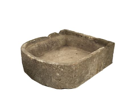 A LARGE CARVED LIMESTONE TROUGH with bowed front and notches cut to the back, approximately 92cm wide x 107cm deep x 32cm hig