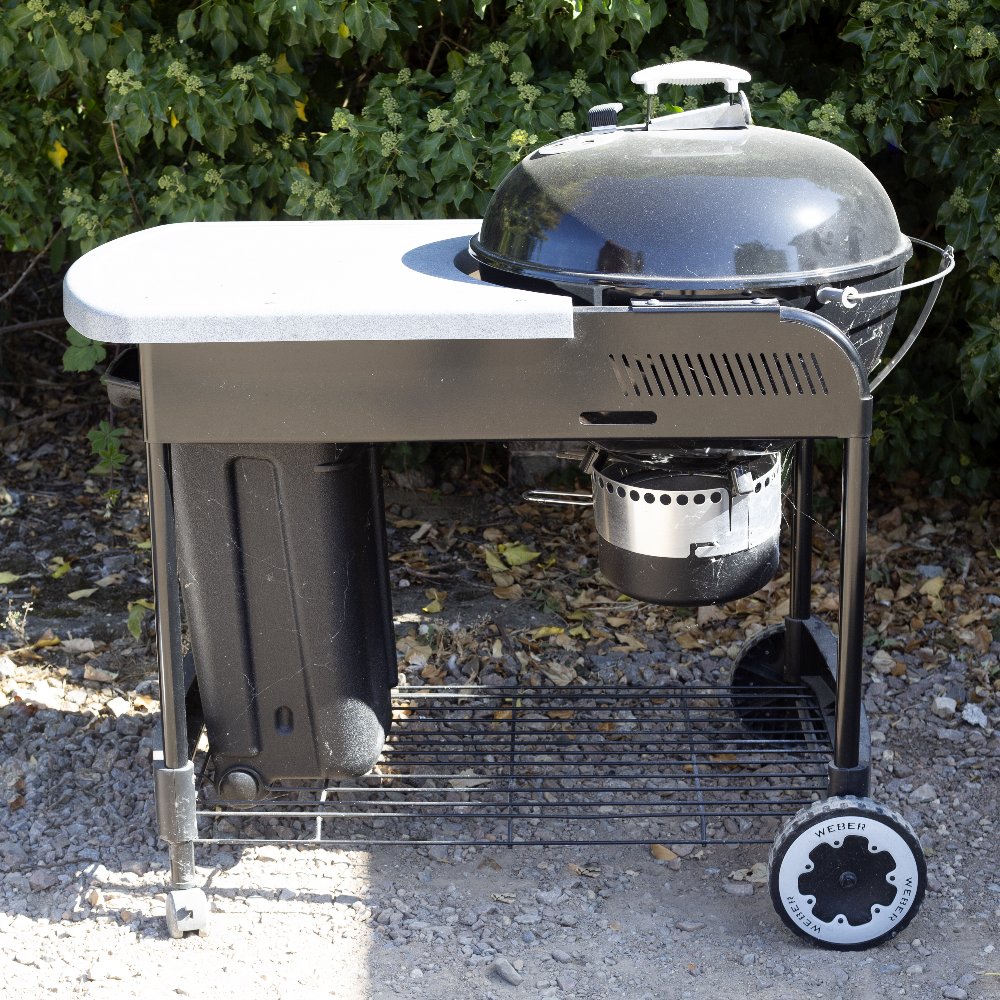 A WEBER BARBECUE with domed cover and on a wheeled stand, 117cm long x