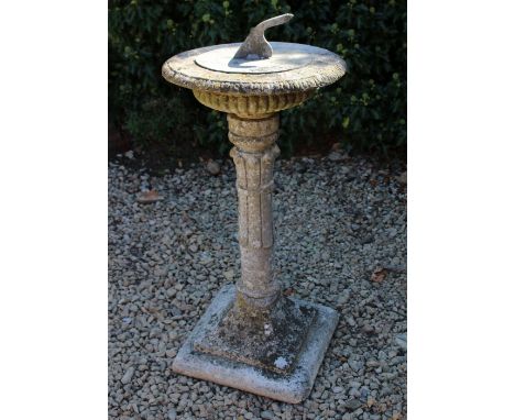 A RECONSTITUTED STONE CIRCULAR SUNDIAL with lead sundial plate and square section spreading base, the top 39cm diameter and a