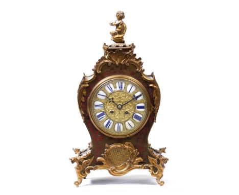 A LATE 19TH CENTURY RED TORTOISE SHELL MANTLE CLOCK with a cherub finial, scrolling gilt mounts and an enamelled dial with Ro