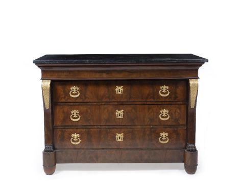 A LOUIS PHILIPPE STYLE BLACK MARBLE TOPPED MAHOGANY COMMODE with four drawers, gilt metal mounts and outset front feet, 130cm