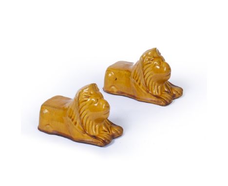 A PAIR OF HONEY GLAZED TERRACOTTA SASH WINDOW SUPPORTS in the form of recumbent lions, 15cm long x 9.5cm high (2)