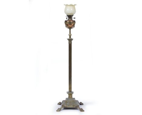 A BRASS STANDARD LAMP OIL LAMP of Corinthian column form on a stepped base and four paw feet, 155cm in height including the s