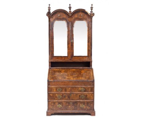 AN 18TH CENTURY AND LATER BUREAU BOOKCASE with double arched top above mirrored doors enclosing fitted drawers and pigeon hol