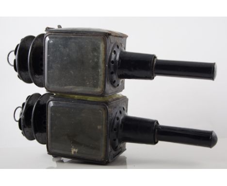 A pair of black metal carriage lamps, 44cms, and a red paraffin road lamp, (3).