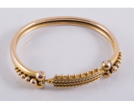 A yellow metal hollow bangle, 6mm wide sprung construction with bead edge panel to front, approximate weight 