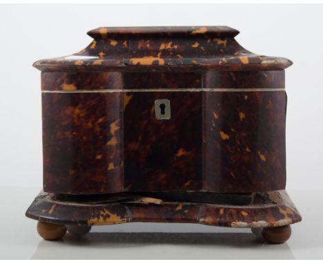 Regency tortoiseshell tea caddy, serpentine front, four ball feet, damaged and with losses, 21cm.
