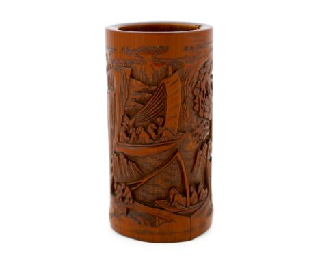 A Chinese bamboo 'river landscape' inscribed brushpot, bitong, 19th century, carved in relief with figures on boats in a moun