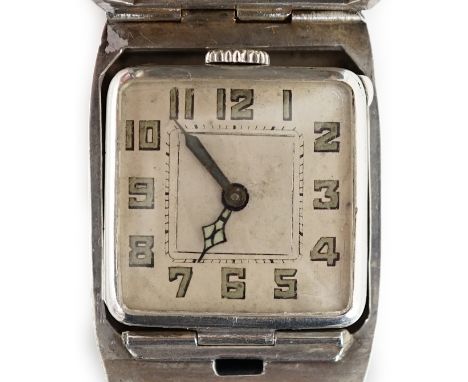 A gentleman's late 1920's silver flip action manual wind rectangular wrist watch, with part engine turned curved hinged cover