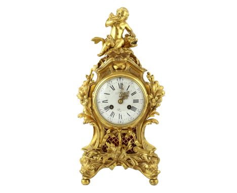 A Louis XVI style ormolu mantel clock, with Cupid and dolphin finial over an enamelled Roman dial, the rococo floral scroll c
