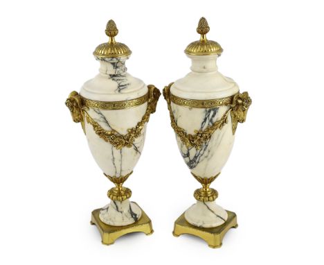A pair of Italian ormolu mounted calacaita marble urns, with fruiting finials and ram's head and swag mounts, 19cm wide, 44cm