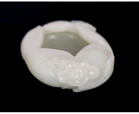 * A Chinese pale celadon jade waterpot, 17th/18th century, formed as overlapping petals and worked with a prunus spray, the s