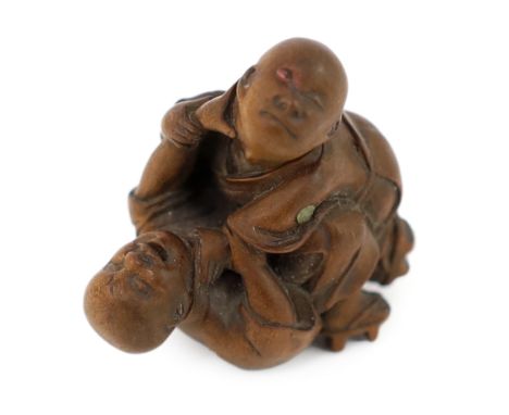 * A Tokyo School carved wood netsuke of two boys fighting, 19th century, signed Kakiman, one boy with horn inlay to his robes