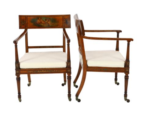 A pair of Edwardian Sheraton revival painted satinwood elbow chairs, decorated with cherubs, flowers and musical trophies, wi