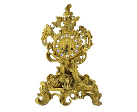 A 19th century French ormolu mantel clock, of asymmetrical scroll form, with enamelled tablet numerals and eight day Raingo F