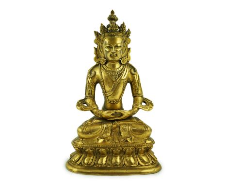 A Tibetan gilt bronze figure of Avalokeshvara, 18th century, seated in padmansana, on a double lotus throne, 16cm high***COND