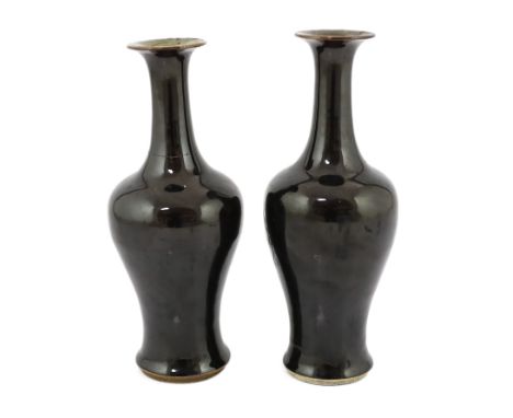 A near pair of Chinese mirror-black glazed vases, Kangxi period, each with a trumpet shaped neck above baluster shaped body, 