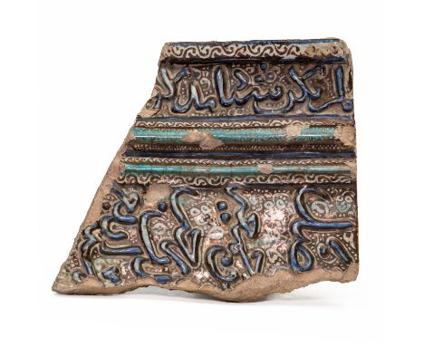 A LARGE KASHAN CALLIGRAPHIC LUSTRE POTTERY TILE FRAGMENTPersia, 13th/14th century Slightly curved, moulded in relief with an 