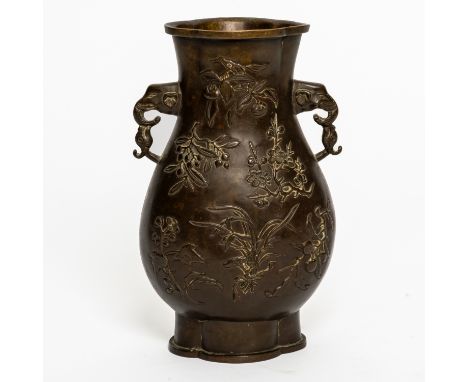 A CHINESE BRONZE PEAR-SHAPED VASE17th/18th century The body cast in relief with with flowers and fruits, the neck flanked by 