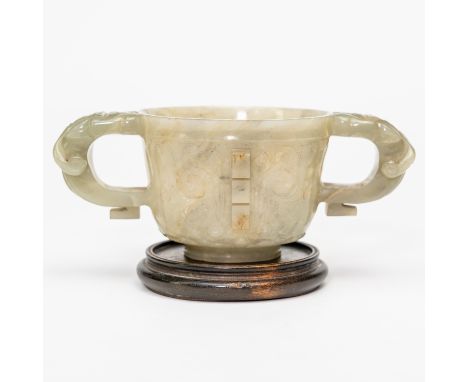 A CHINESE JADE ARCHAISTIC CUP (2)Qing dynasty Flared cylindrical form set with lion mask handles, the sides carved with taoti